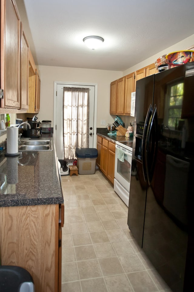 kitchen featuring dark stone counters, white electric range, sink, light tile patterned flooring, and black fridge with ice dispenser