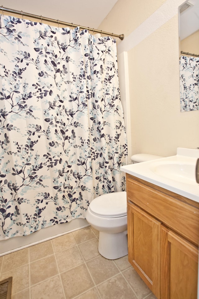 bathroom with tile patterned flooring, vanity, and toilet