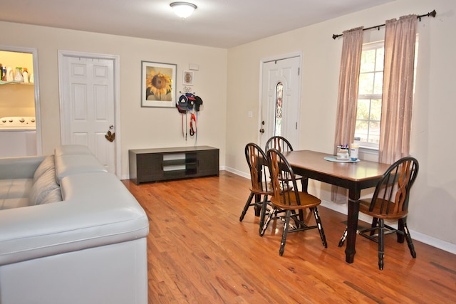 dining room with washer / clothes dryer and light hardwood / wood-style flooring