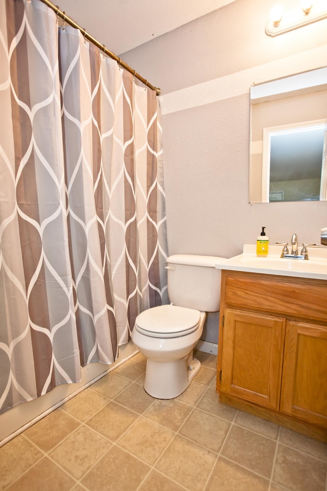 bathroom featuring tile patterned flooring, vanity, and toilet