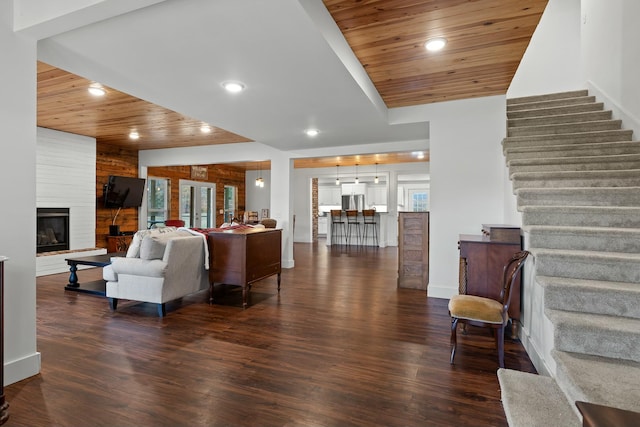 living room featuring wooden ceiling, a wealth of natural light, and dark wood-type flooring