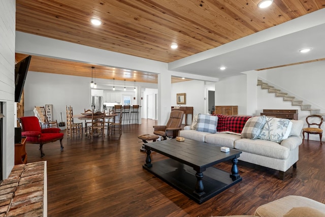 living room with dark hardwood / wood-style flooring, wood ceiling, and a brick fireplace