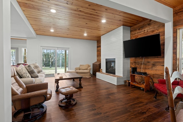 living room featuring dark hardwood / wood-style floors, wood ceiling, a fireplace, and wooden walls