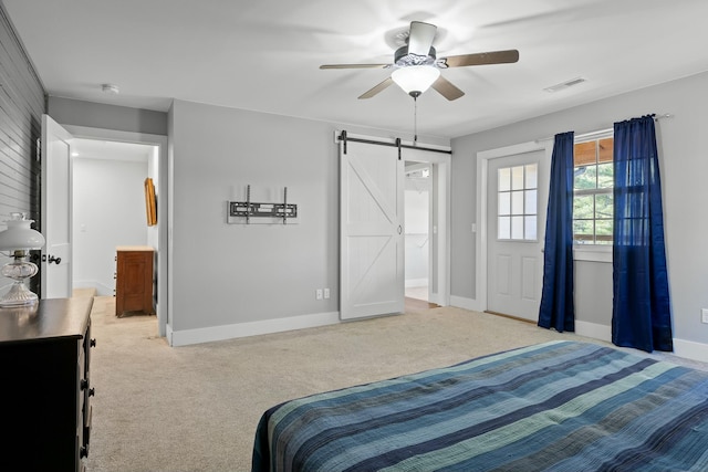 carpeted bedroom featuring ceiling fan, a barn door, and connected bathroom