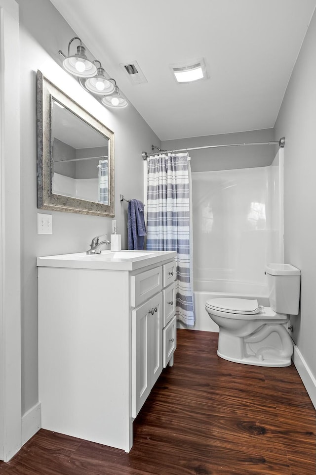 full bathroom with hardwood / wood-style floors, vanity, toilet, and shower / tub combo