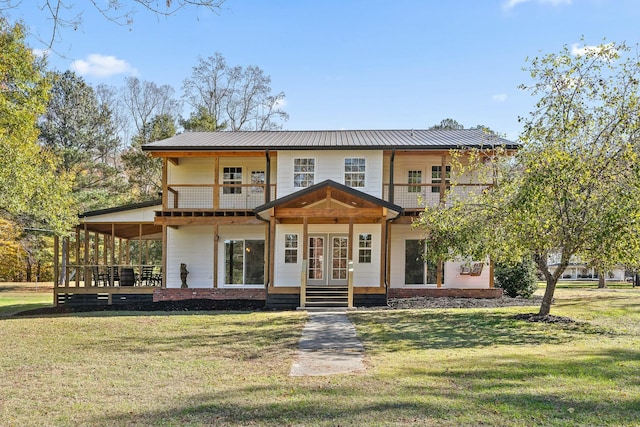 view of front facade featuring a front lawn, french doors, and a balcony