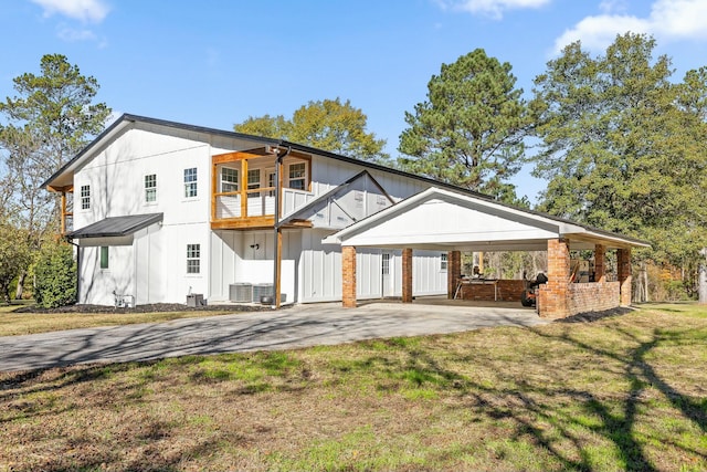 exterior space with a lawn, ceiling fan, central AC, a balcony, and a carport