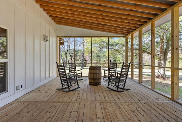 unfurnished sunroom featuring vaulted ceiling and a healthy amount of sunlight