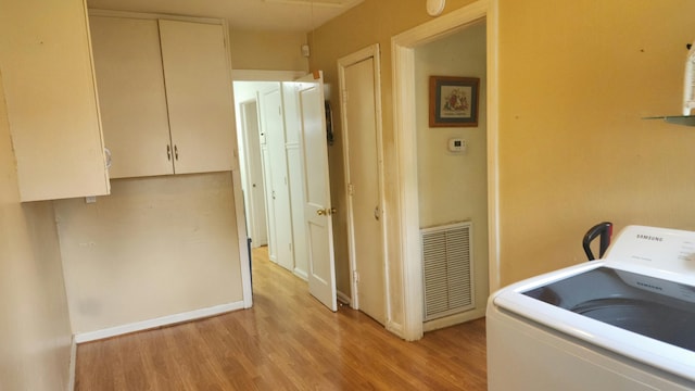 laundry area with washer / dryer and light wood-type flooring