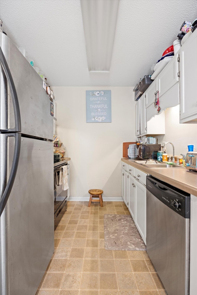 kitchen with white cabinets, sink, stainless steel appliances, and a textured ceiling