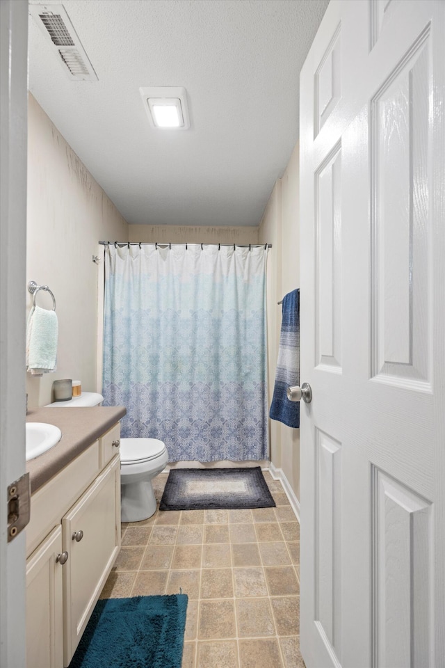 full bathroom with a textured ceiling, vanity, toilet, and shower / bath combo with shower curtain