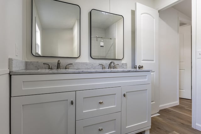 bathroom featuring hardwood / wood-style flooring, vanity, and a shower with shower door