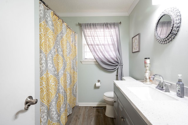 bathroom featuring crown molding, a textured ceiling, toilet, vanity, and hardwood / wood-style flooring