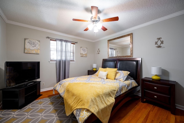 bedroom featuring a textured ceiling, hardwood / wood-style flooring, ceiling fan, and ornamental molding