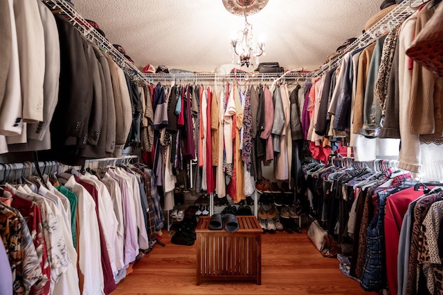 walk in closet featuring a notable chandelier and light hardwood / wood-style floors