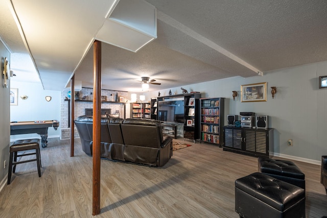 living room featuring ceiling fan, a textured ceiling, and hardwood / wood-style flooring