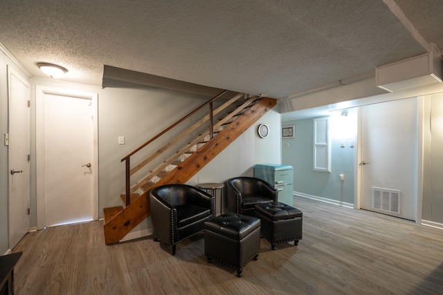 interior space featuring wood-type flooring and a textured ceiling