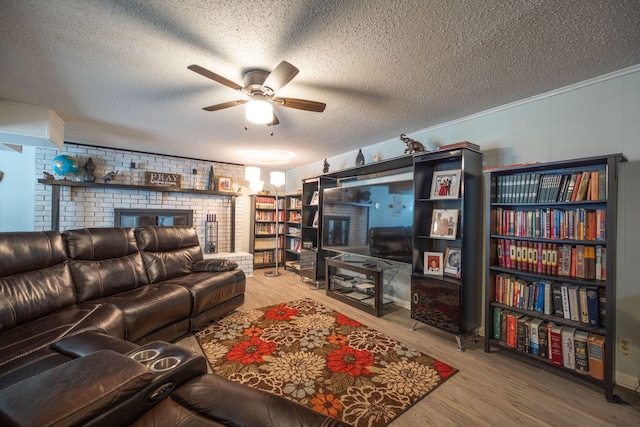 living room with ceiling fan, wood-type flooring, and a textured ceiling