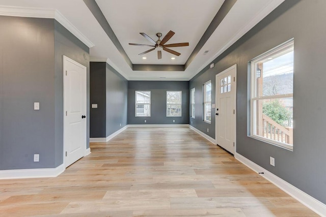 foyer entrance featuring ornamental molding, light hardwood / wood-style floors, ceiling fan, and a tray ceiling