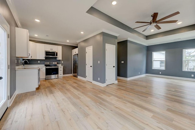 kitchen with sink, light hardwood / wood-style flooring, ceiling fan, appliances with stainless steel finishes, and white cabinetry