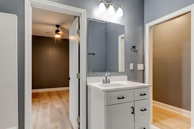 bathroom featuring wood-type flooring, vanity, and ceiling fan