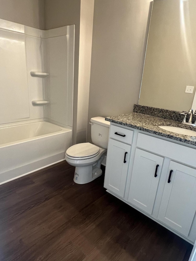 full bathroom with bathtub / shower combination, wood-type flooring, vanity, and toilet