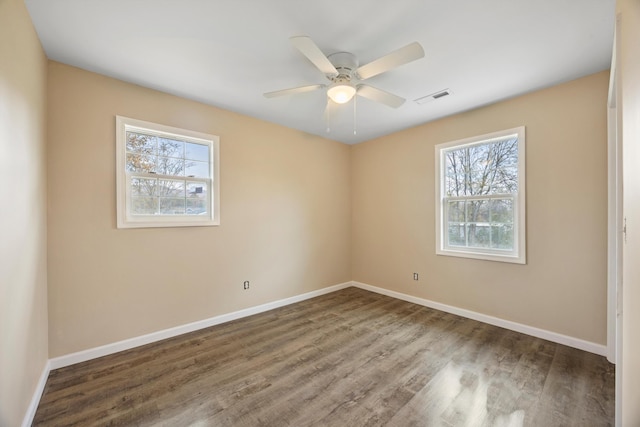 empty room with hardwood / wood-style floors, ceiling fan, and a wealth of natural light