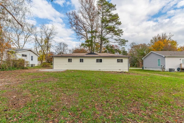 back of property featuring central AC and a lawn