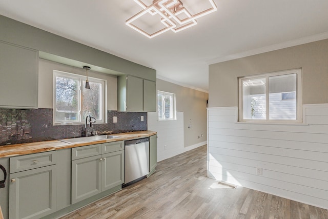 kitchen with a wealth of natural light, light hardwood / wood-style flooring, stainless steel dishwasher, and sink