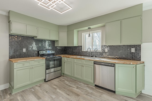 kitchen featuring butcher block counters, light hardwood / wood-style flooring, green cabinets, and stainless steel appliances