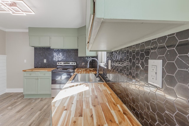 kitchen with butcher block countertops, green cabinets, sink, and stainless steel range with electric cooktop