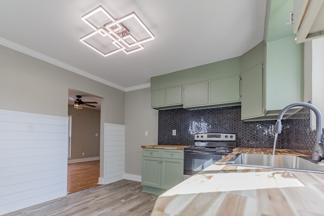 kitchen with wooden counters, sink, green cabinetry, light hardwood / wood-style floors, and stainless steel range with electric cooktop