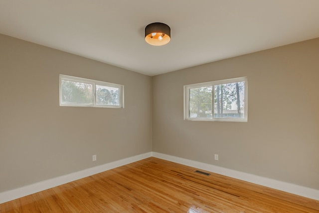 spare room with plenty of natural light and wood-type flooring