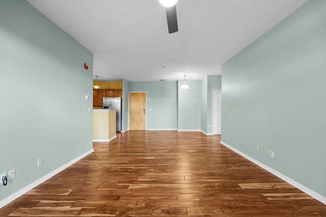 empty room with ceiling fan and dark wood-type flooring