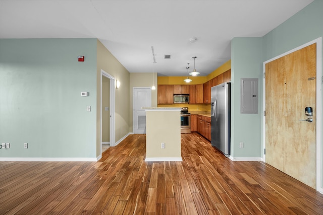 kitchen with dark hardwood / wood-style flooring, stainless steel appliances, pendant lighting, a center island, and electric panel