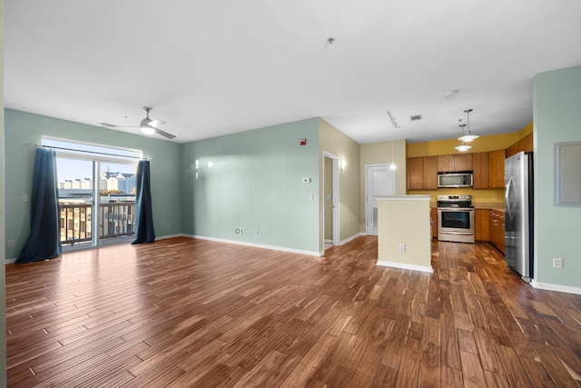 unfurnished living room featuring ceiling fan and dark hardwood / wood-style flooring