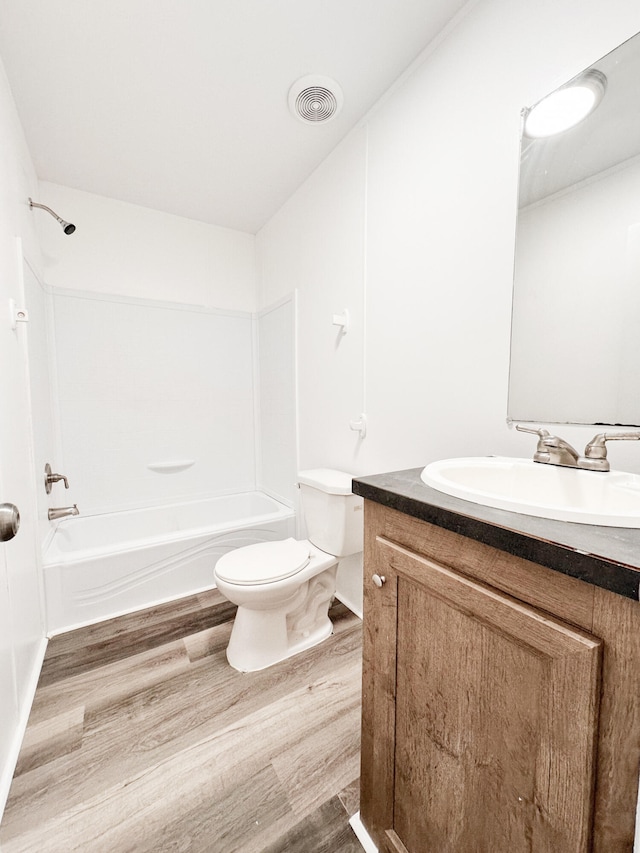 full bathroom with vanity,  shower combination, hardwood / wood-style flooring, and toilet