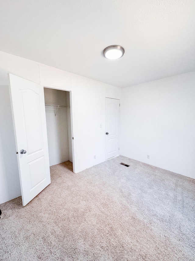 unfurnished bedroom with a closet and carpet floors