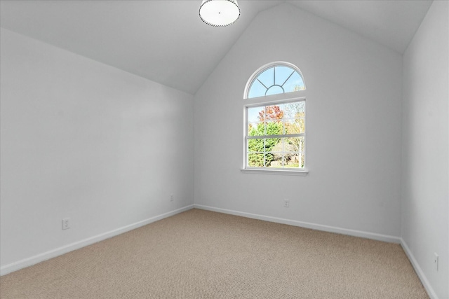 spare room featuring carpet floors and vaulted ceiling