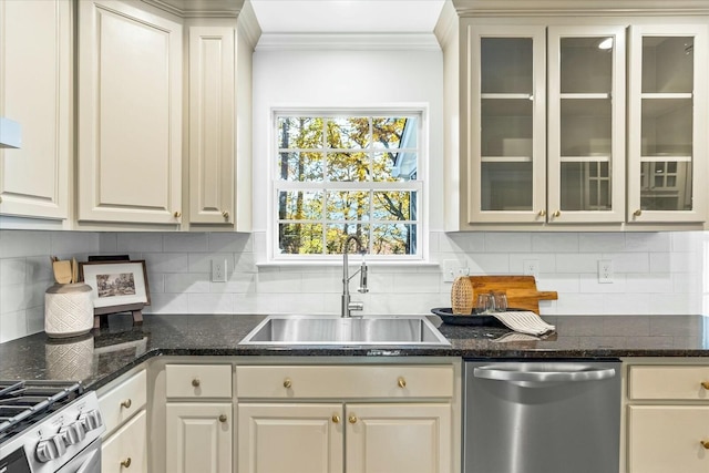 kitchen featuring appliances with stainless steel finishes, backsplash, dark stone counters, and sink