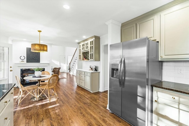 kitchen with decorative backsplash, stainless steel fridge, decorative light fixtures, a premium fireplace, and dark hardwood / wood-style floors