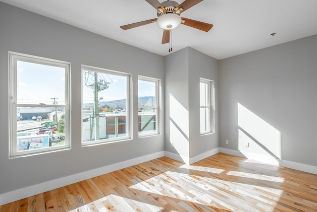 spare room featuring light hardwood / wood-style floors, plenty of natural light, and ceiling fan