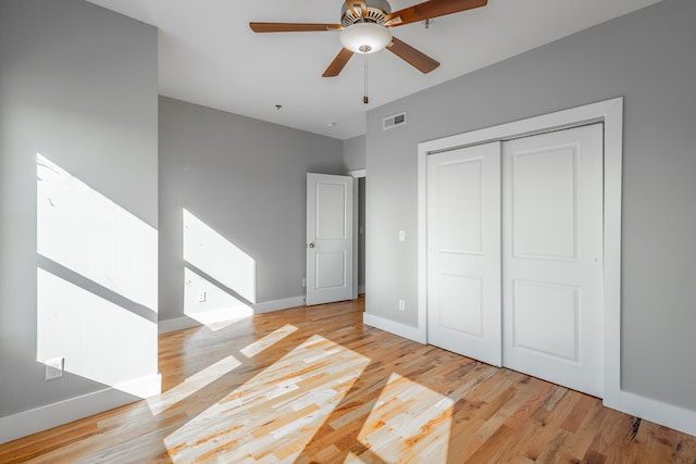 unfurnished bedroom with ceiling fan, light hardwood / wood-style floors, and a closet