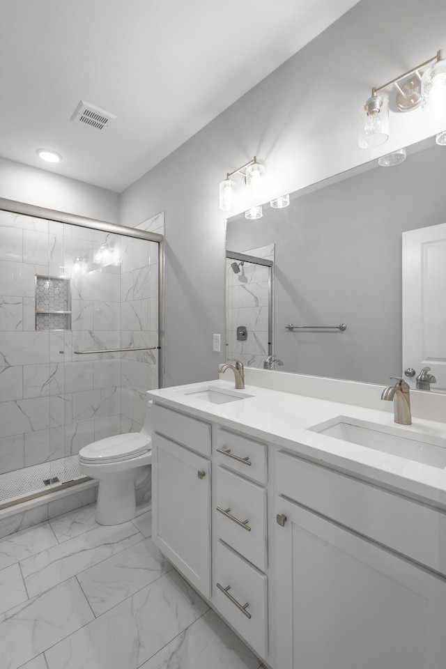 bathroom featuring vanity, a shower with shower door, and toilet