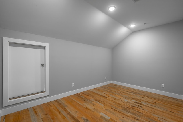 bonus room featuring light wood-type flooring and lofted ceiling