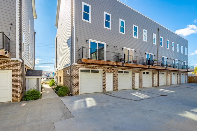 back of property with a garage and a balcony