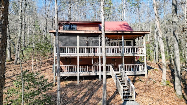 view of front of home with a wooden deck and a sunroom