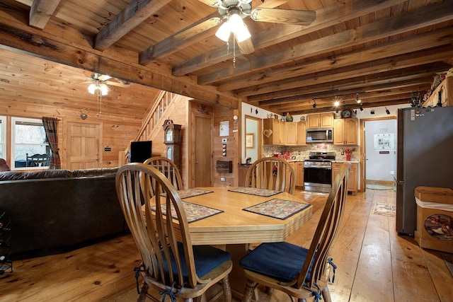 dining space with wood ceiling, light hardwood / wood-style flooring, wooden walls, ceiling fan, and beam ceiling