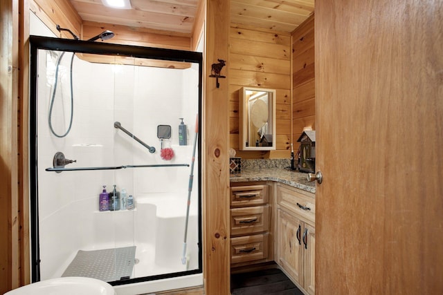 bathroom with vanity, wooden walls, an enclosed shower, and wood ceiling