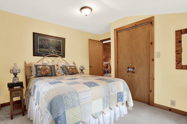 bedroom featuring lofted ceiling, carpet floors, and a closet